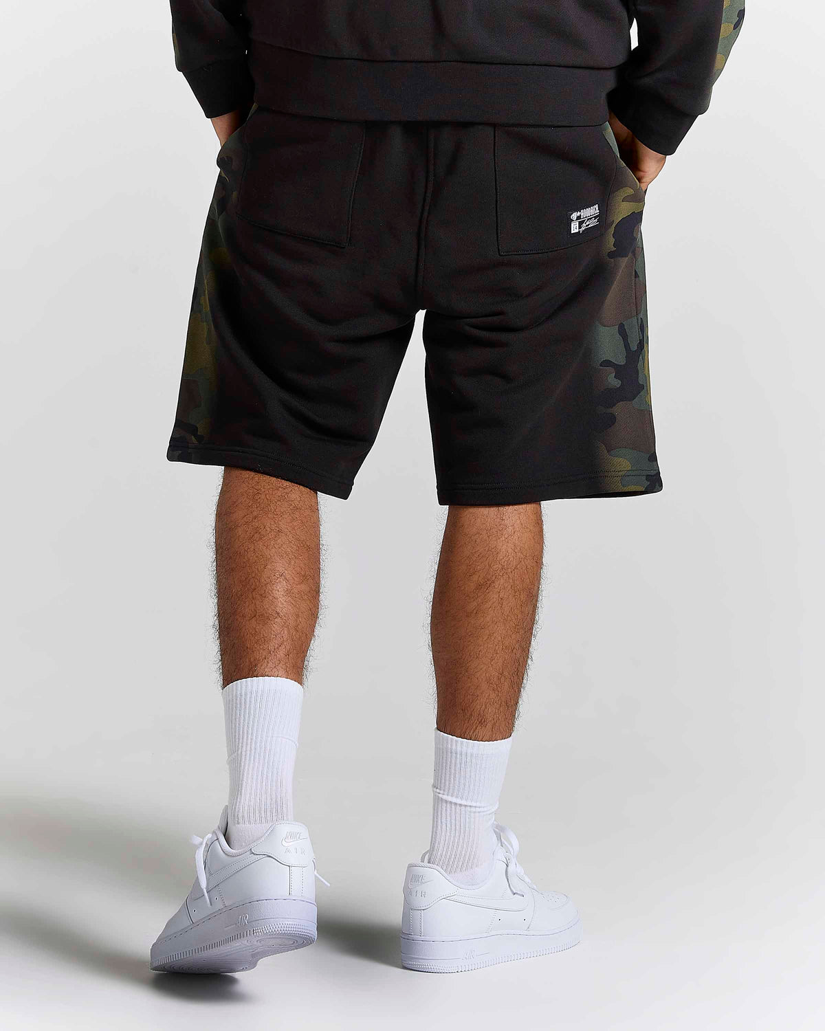 Displays a model wearing the Black Camo 'Hoodrich' branded men's Shade Matching Shorts Set