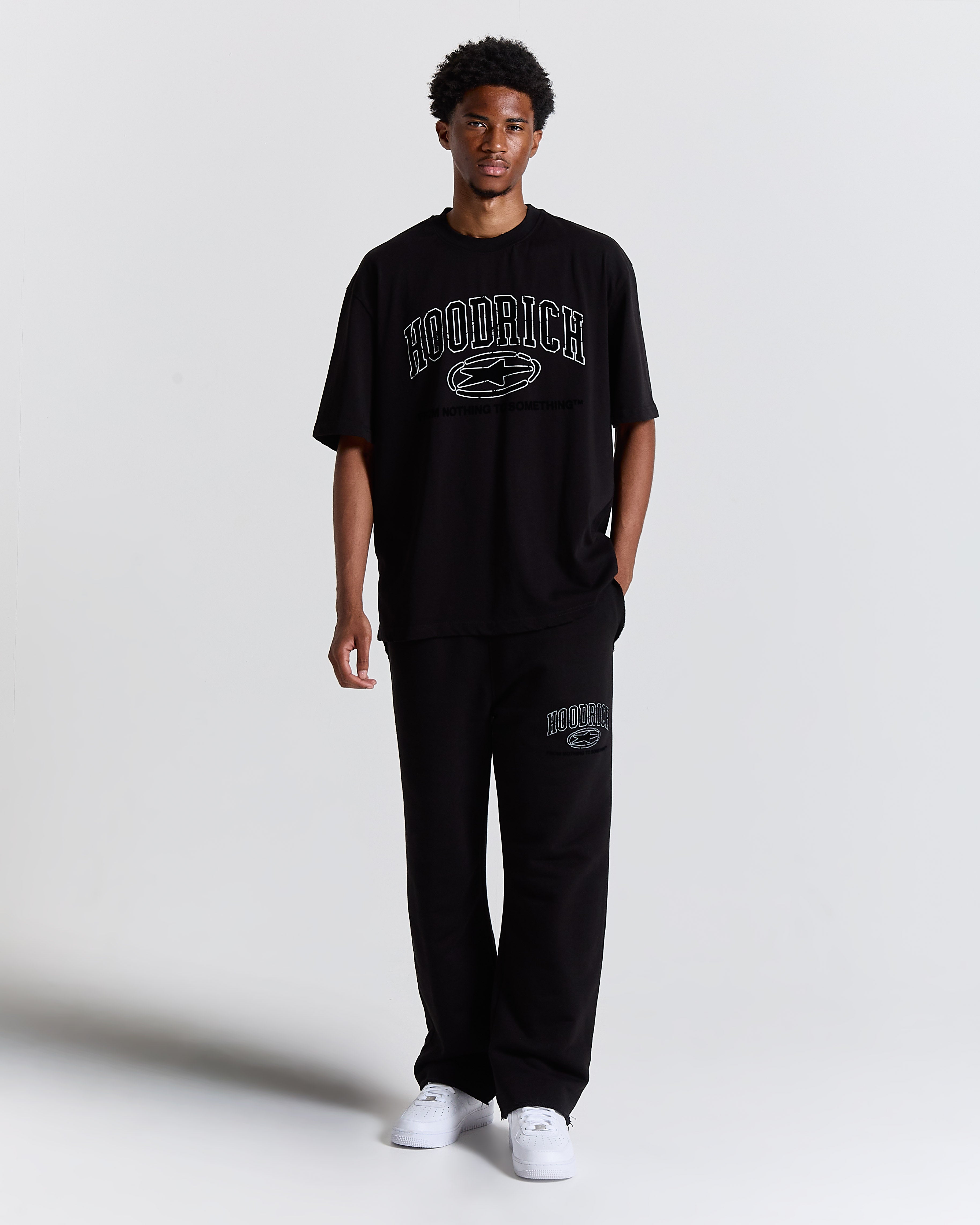 Front view of a male model wearing a regular-fit black Hoodrich t-shirt.