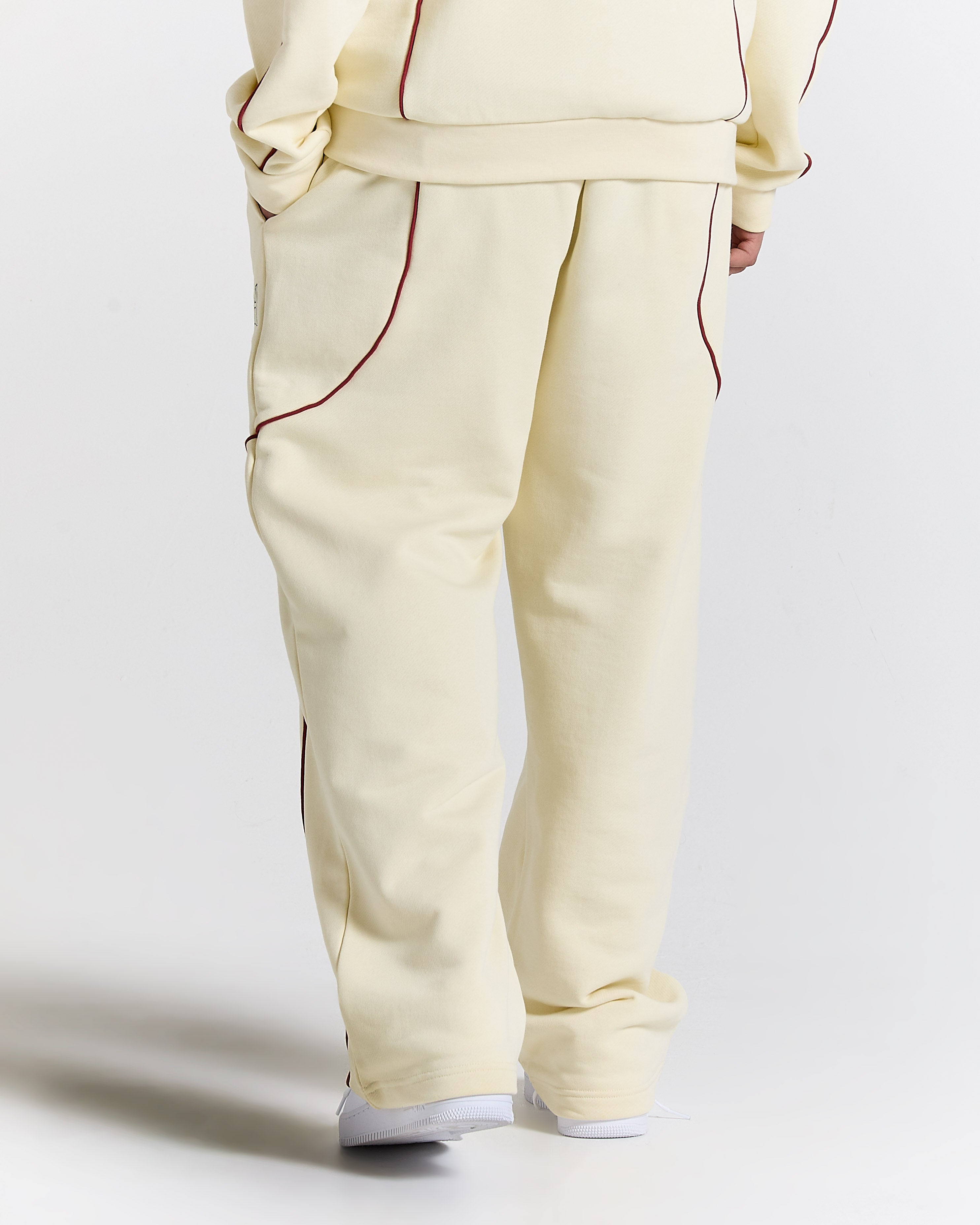 Beige tracksuit with red piping on a white background