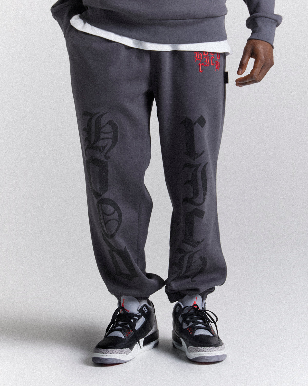 Displays a model wearing the Grey 'Hoodrich' branded men's Crown Full Tracksuit