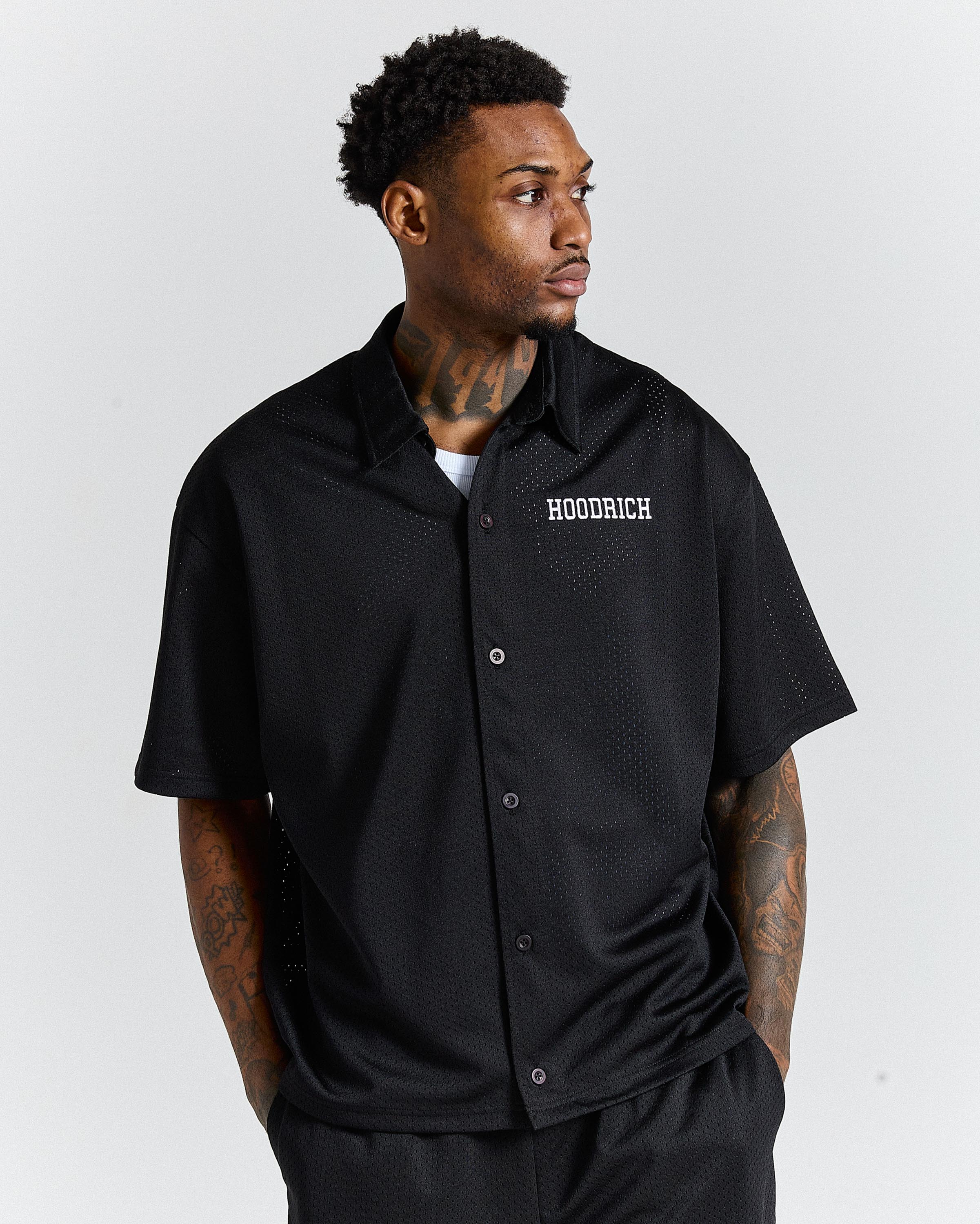 Man wearing a black 'HOODRICH' shirt on a white background