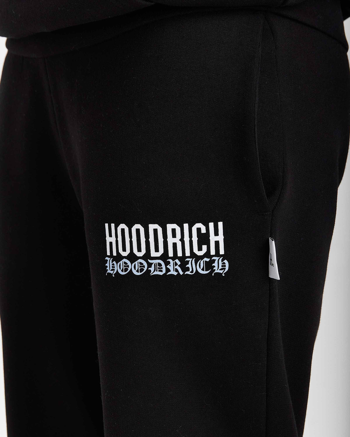 Displays a model wearing the Black 'Hoodrich' branded women's Flex Full Tracksuit featuring the hoodrich branding details