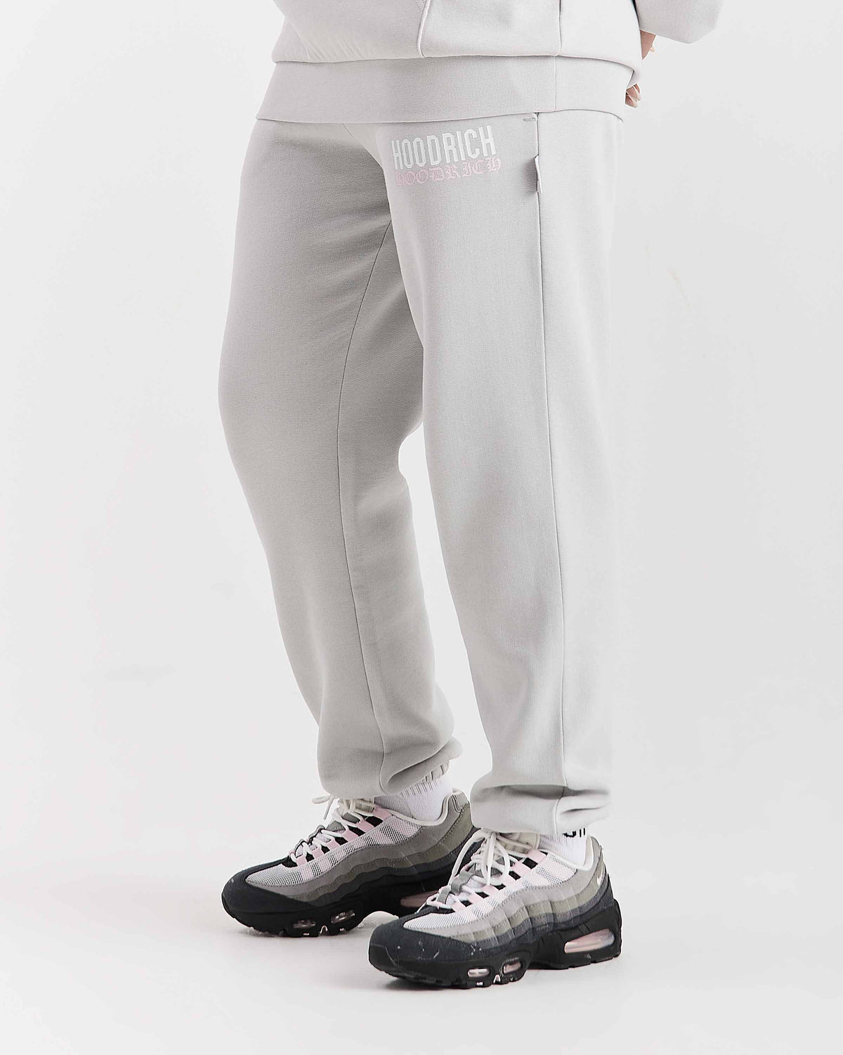 Displays a model wearing the Grey 'Hoodrich' branded women's Flex Full Tracksuit
