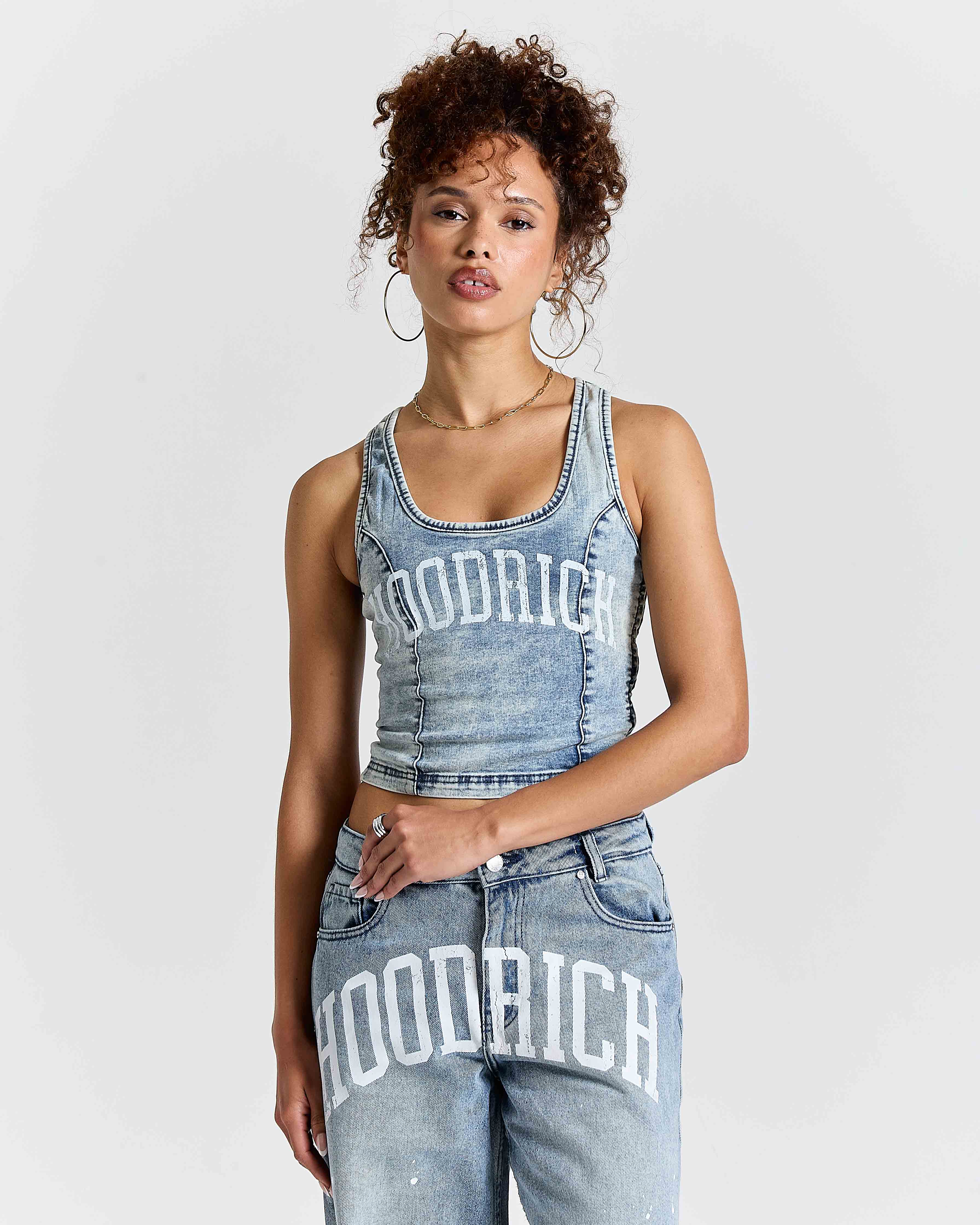 Woman wearing a denim outfit with 'hoodrich' branding on a white background