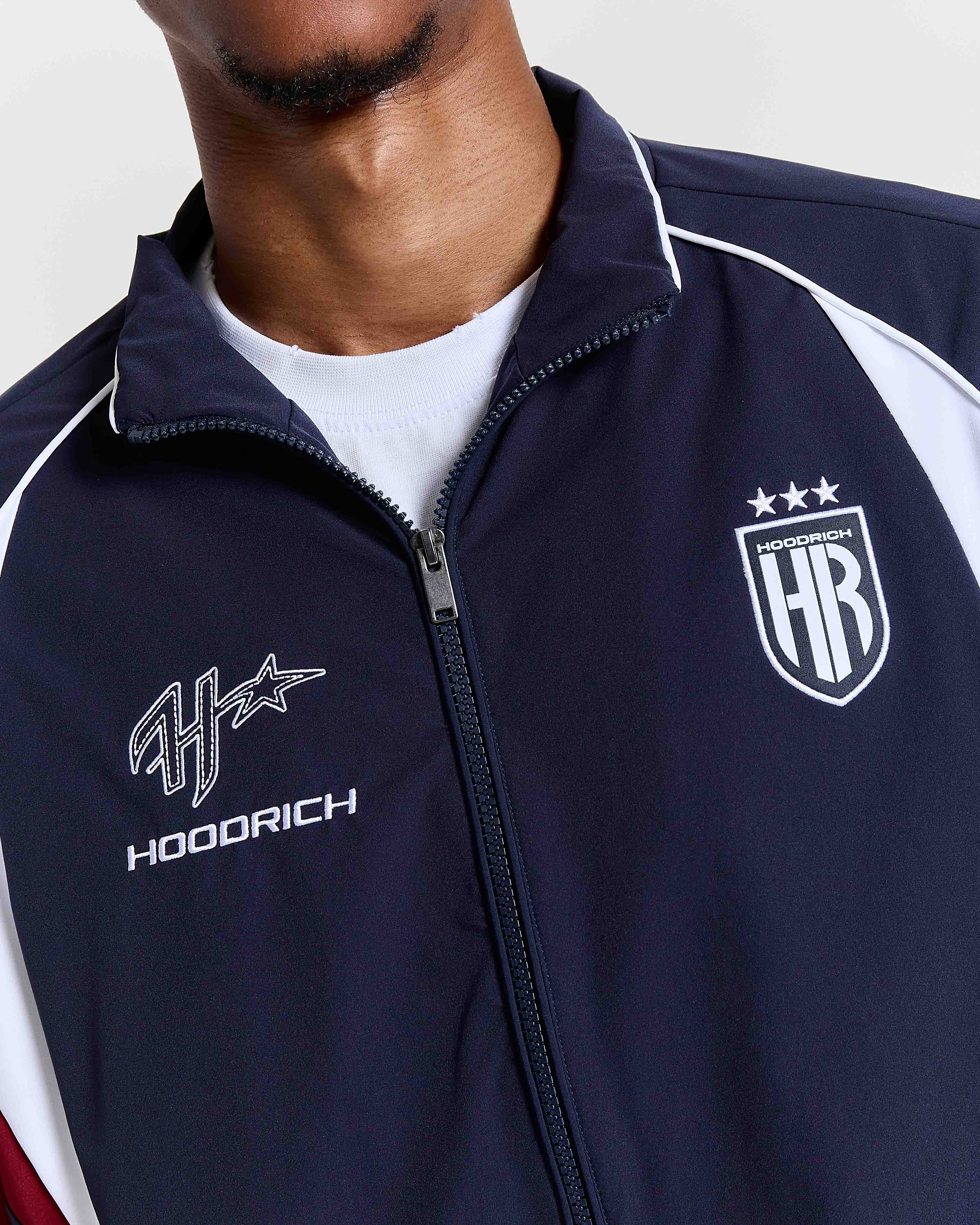 Navy blue jacket with 'Hoodrich' logo on a white background