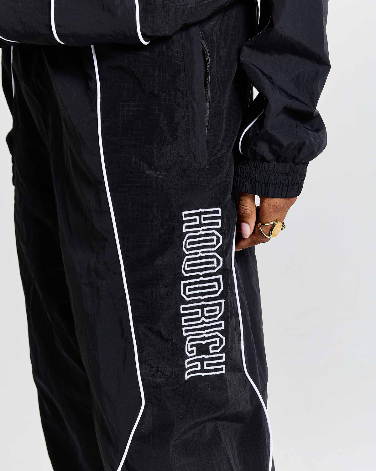 Black tracksuit with 'Hoodrich' branding on a white background