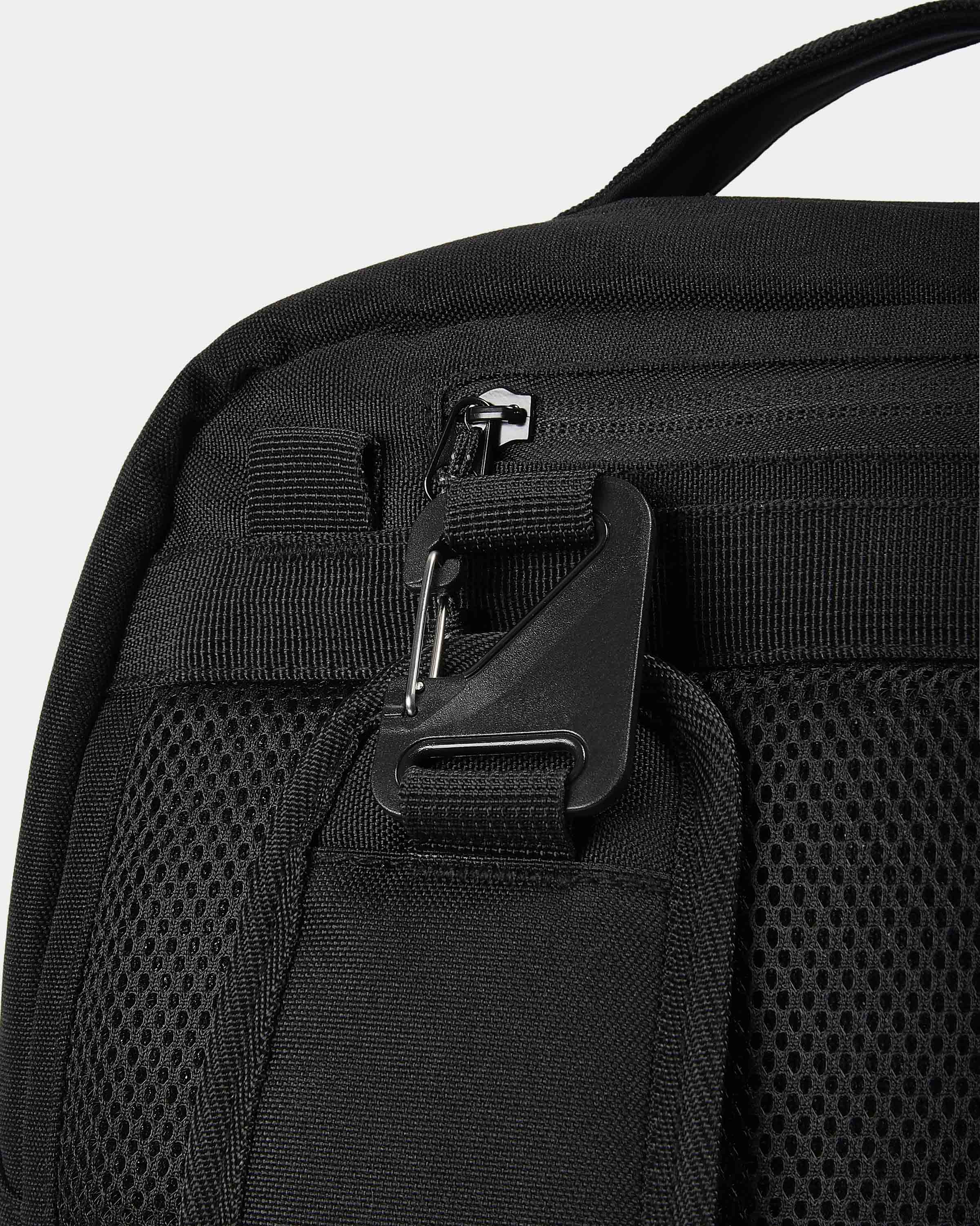 Close-up of a black backpack with zippers on a light gray background