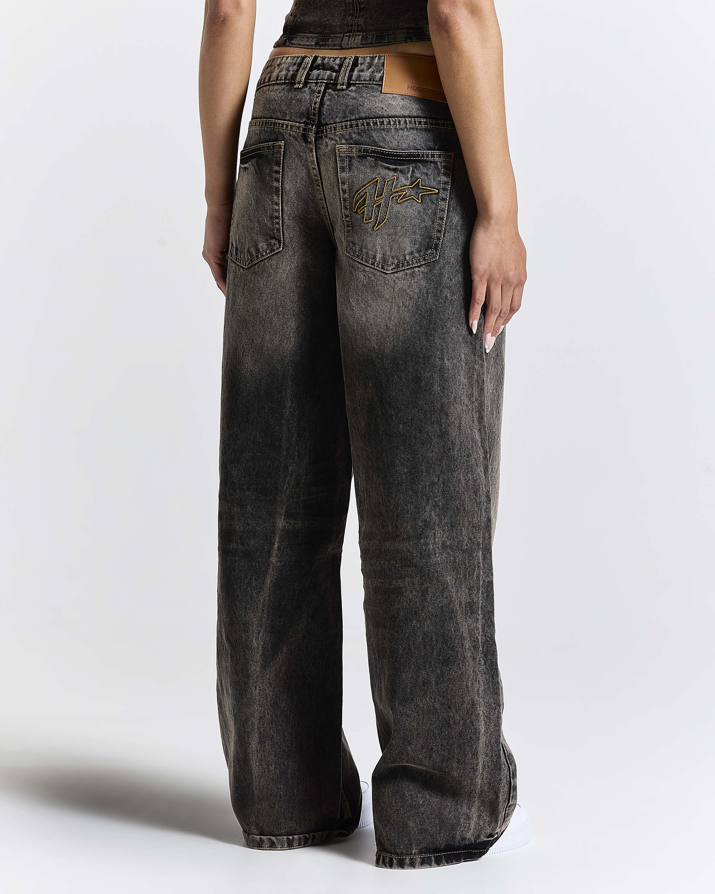 Person wearing wide-leg jeans on a plain background