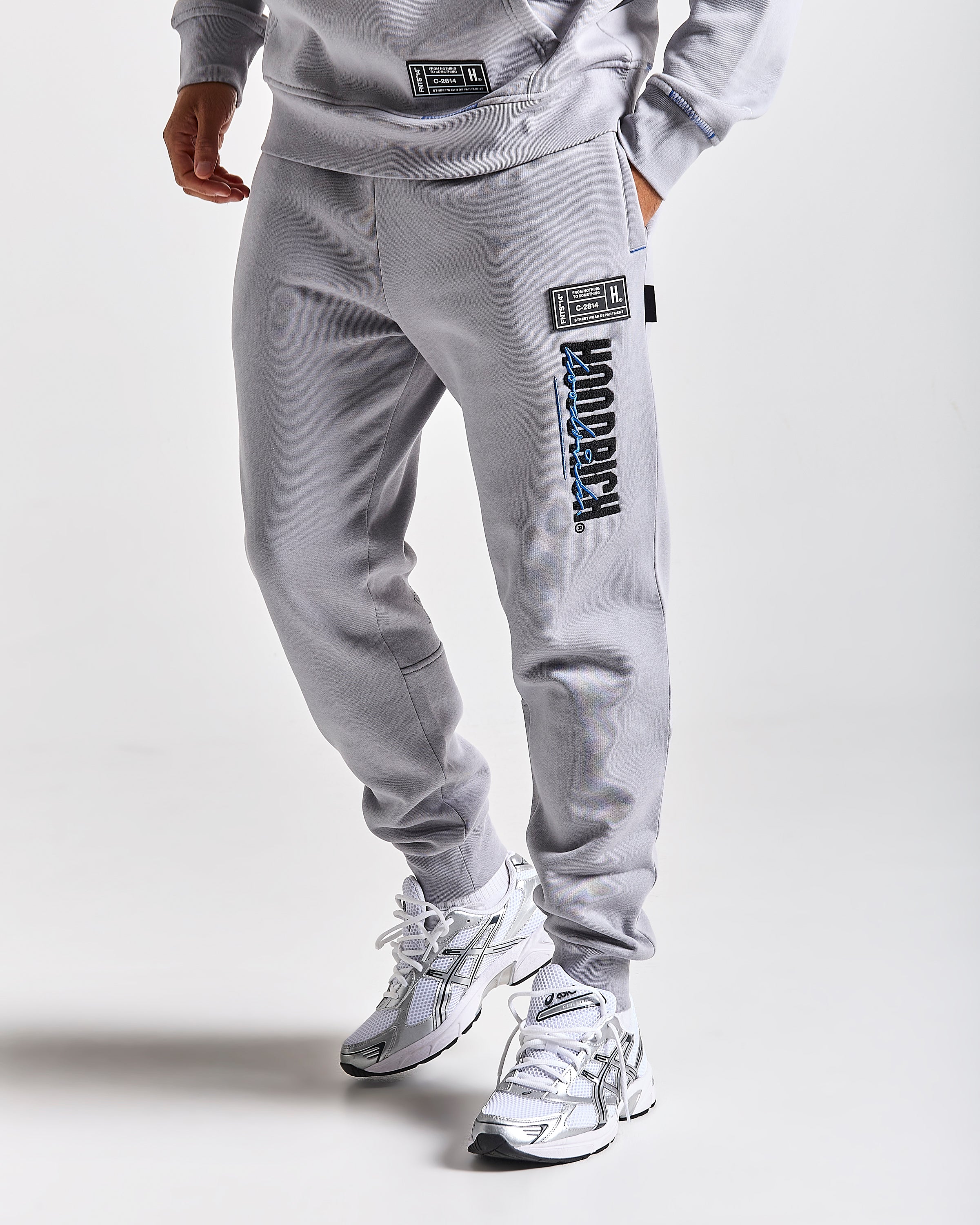 Displays a model wearing the Grey 'Hoodrich' branded men's blend Full Tracksuit 