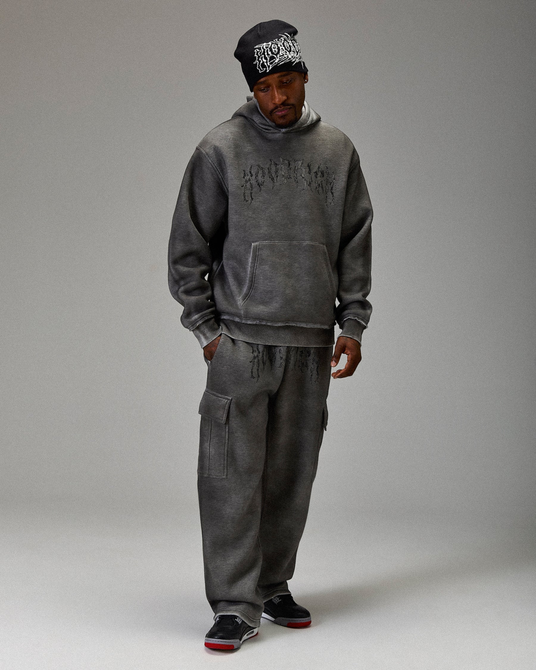 Person wearing a gray tracksuit with 'Hoodrich' branding on a gray background