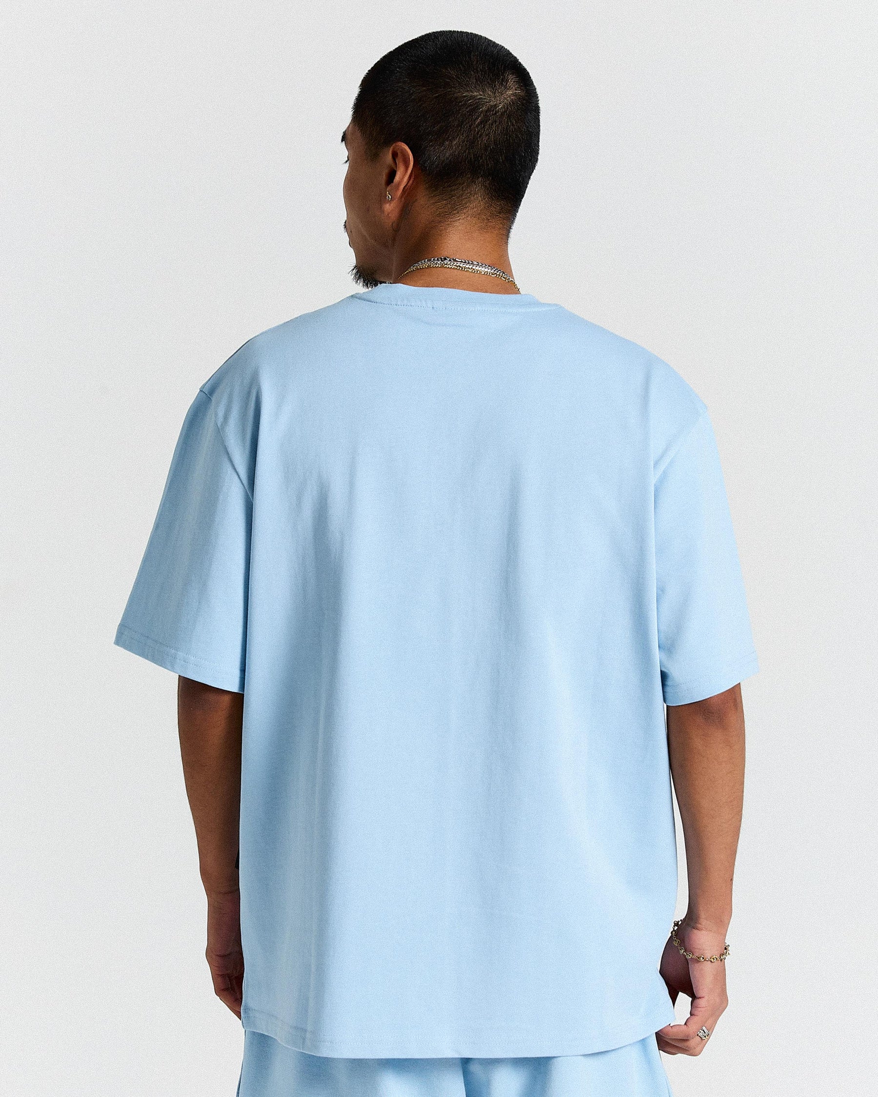 Person wearing a light blue t-shirt on a plain background