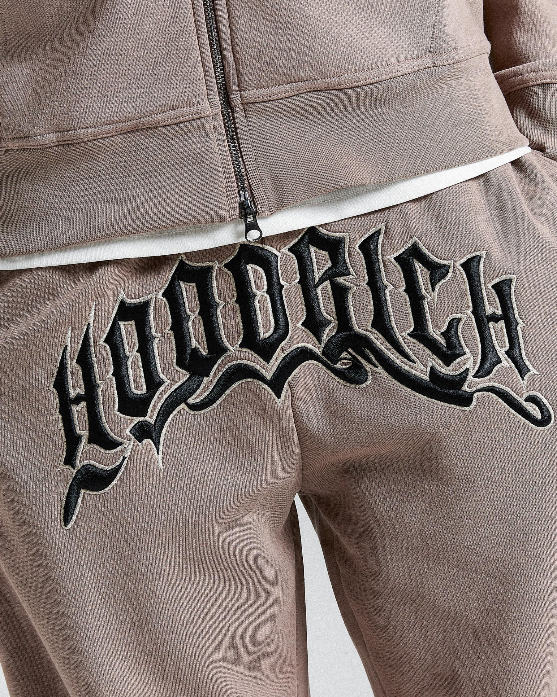 Brown tracksuit with 'Hoodrich' logo on a plain background