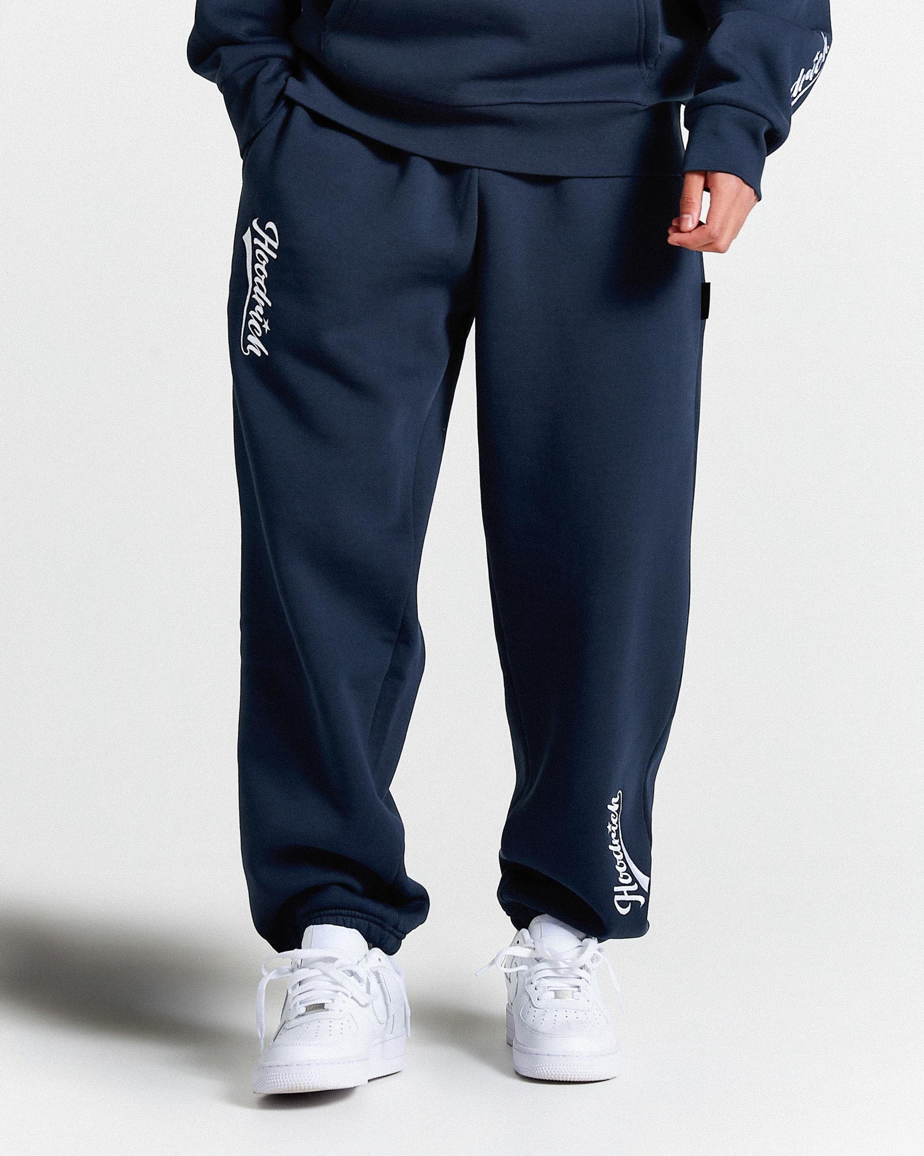 Navy tracksuit with white branding on a light gray background