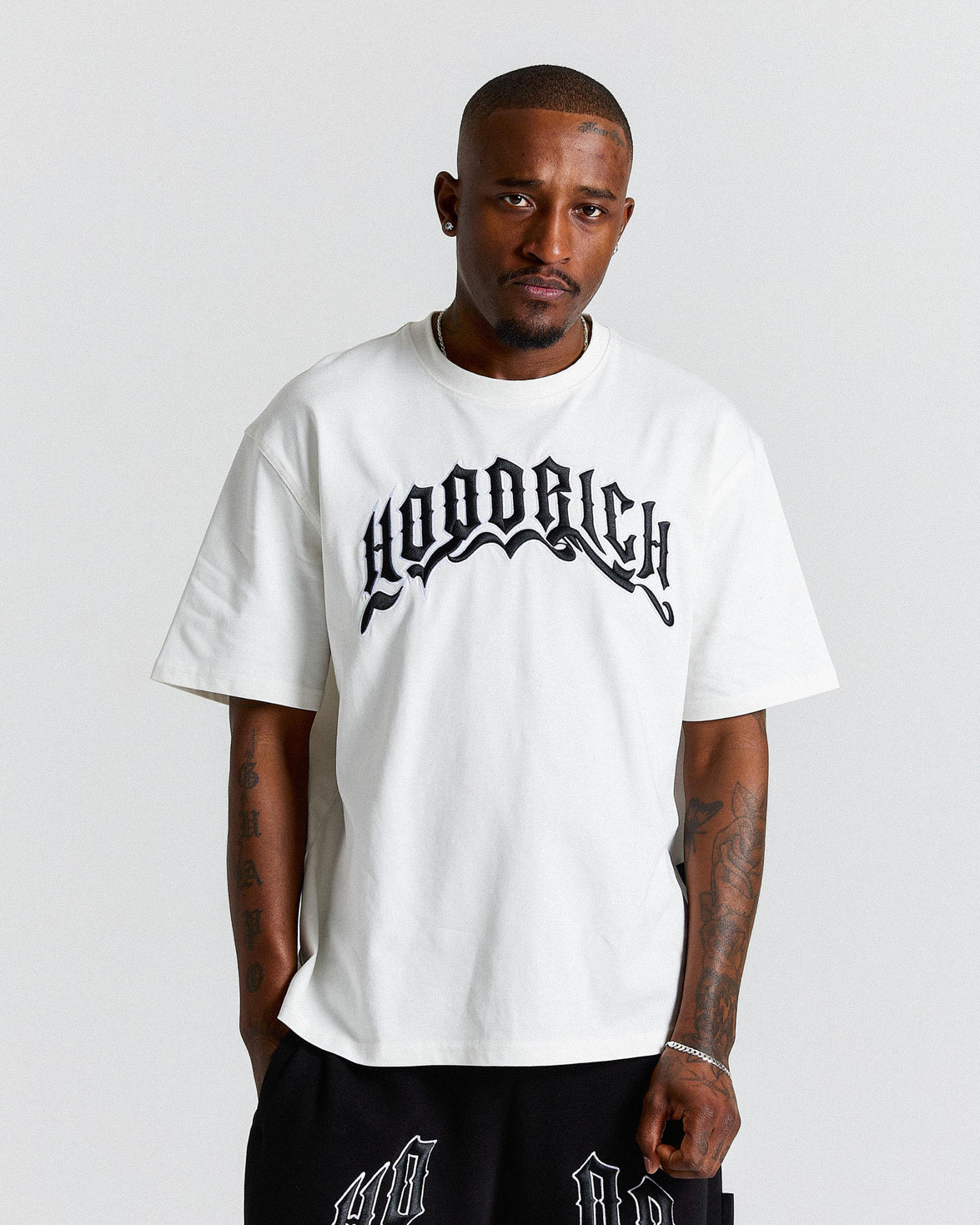 Man wearing a white t-shirt with black text on a plain background