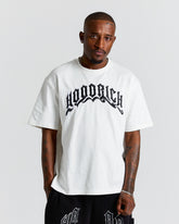 Man wearing a white t-shirt with black text on a plain background