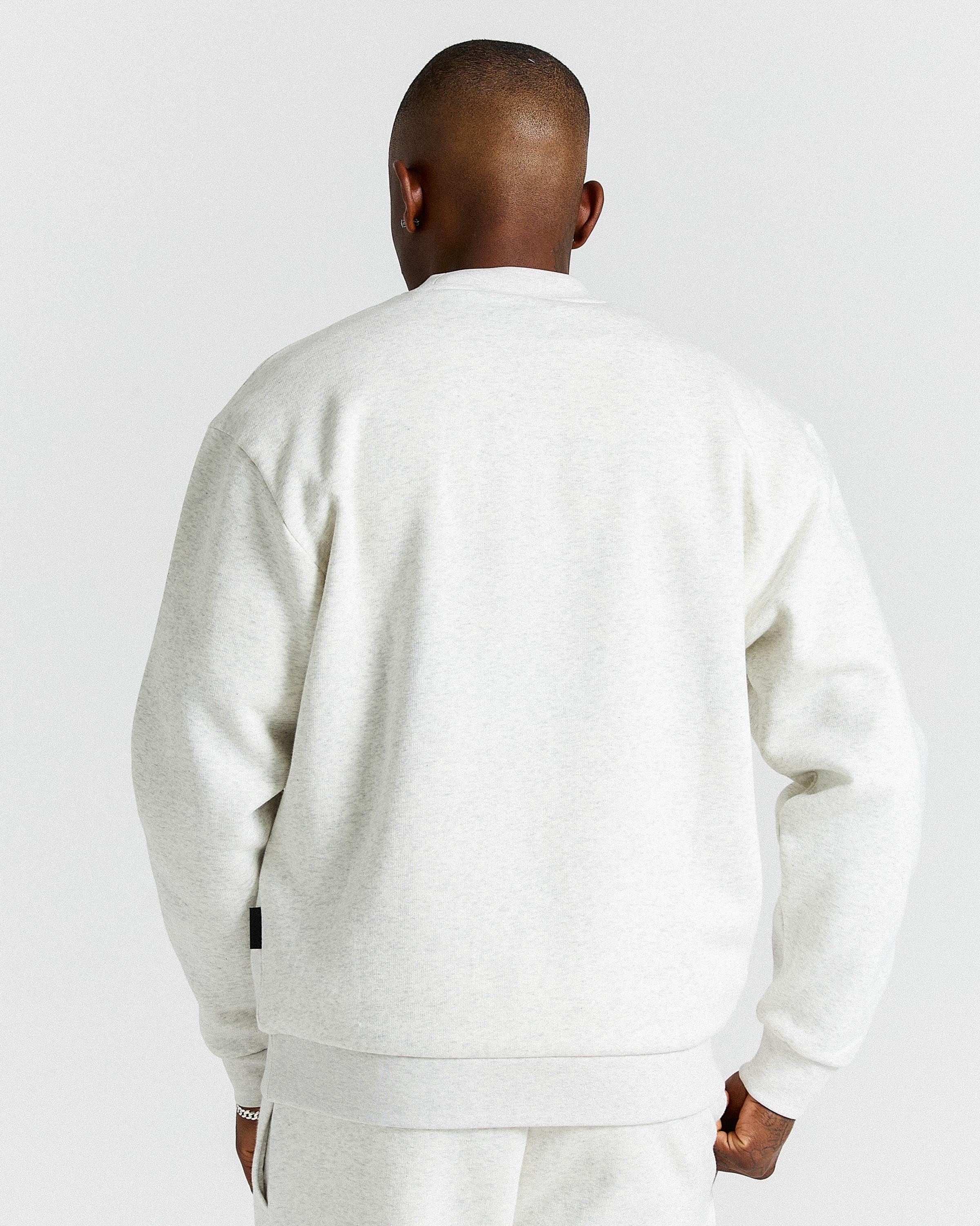 Person wearing a light grey tracksuit against a plain background.