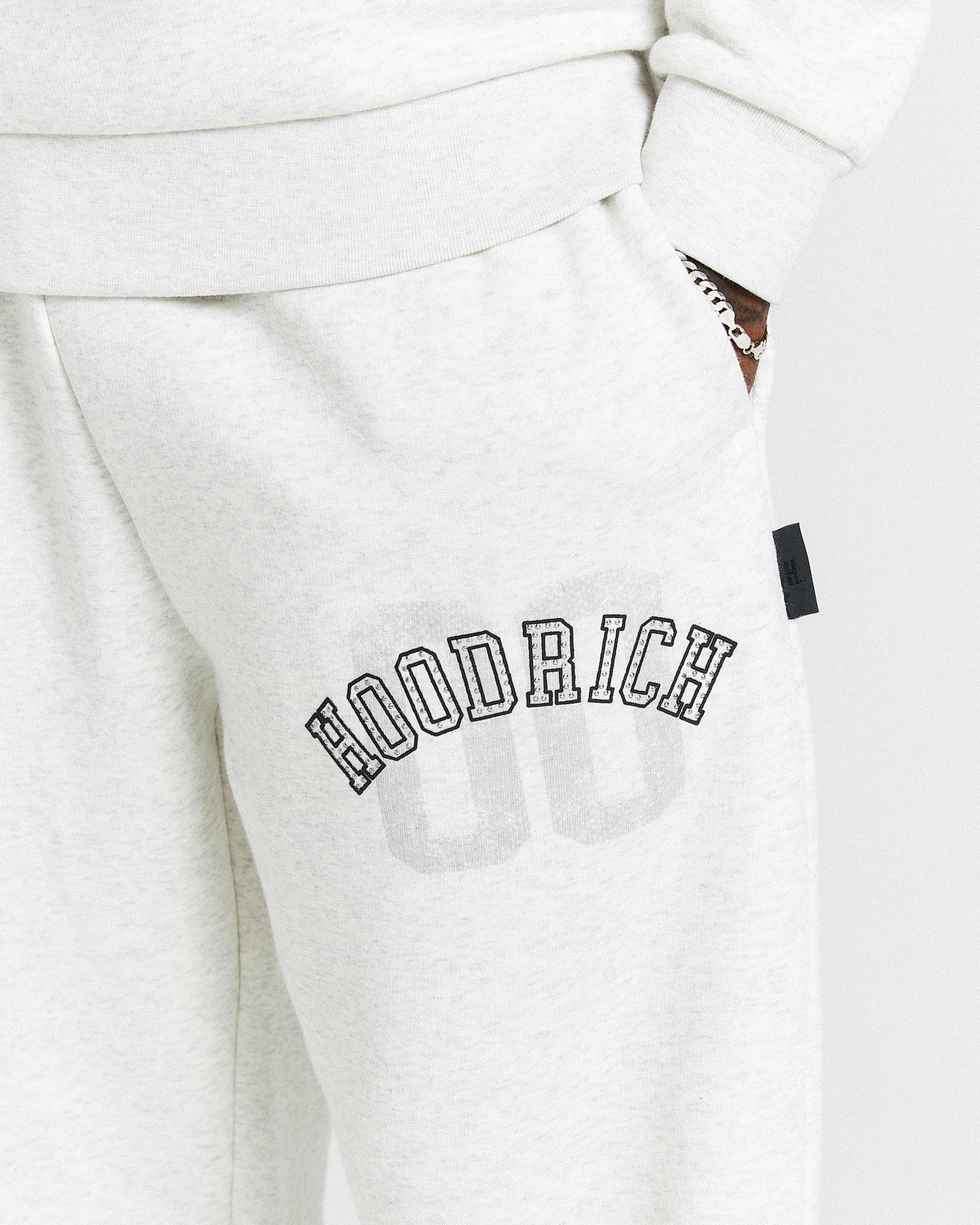 White sweatpants with 'Hoodrich' branding on a white background