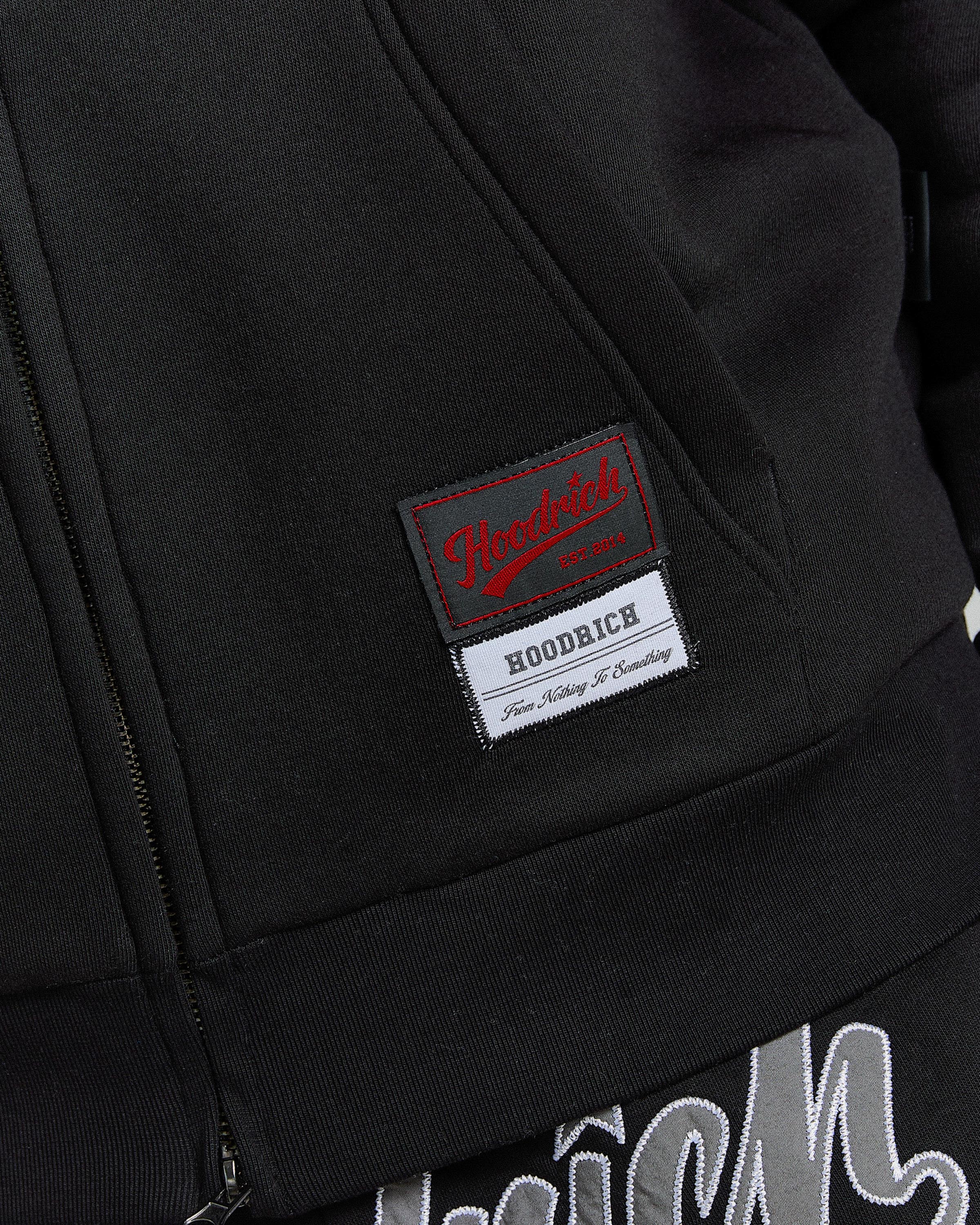 Close-up of a black jacket with a brand label on the chest.