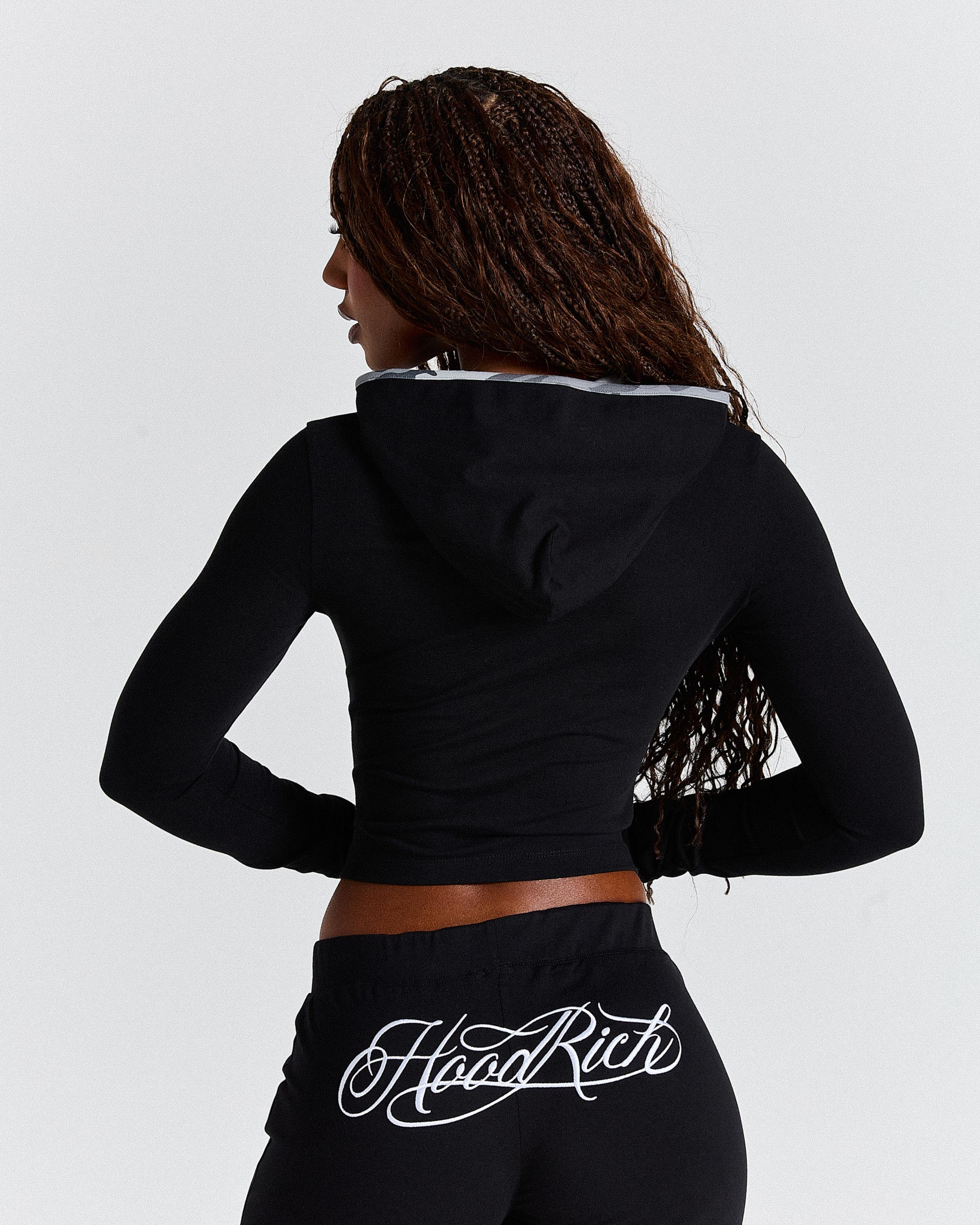 Person wearing a black hoodie with 'Hoodrich' branding on a light grey background