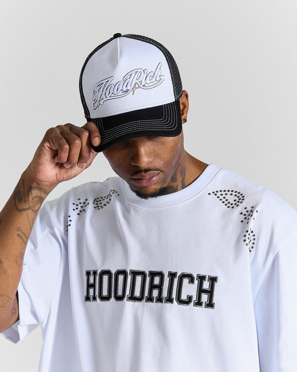 Person wearing a white cap with black text and a matching white t-shirt with black text on a plain background