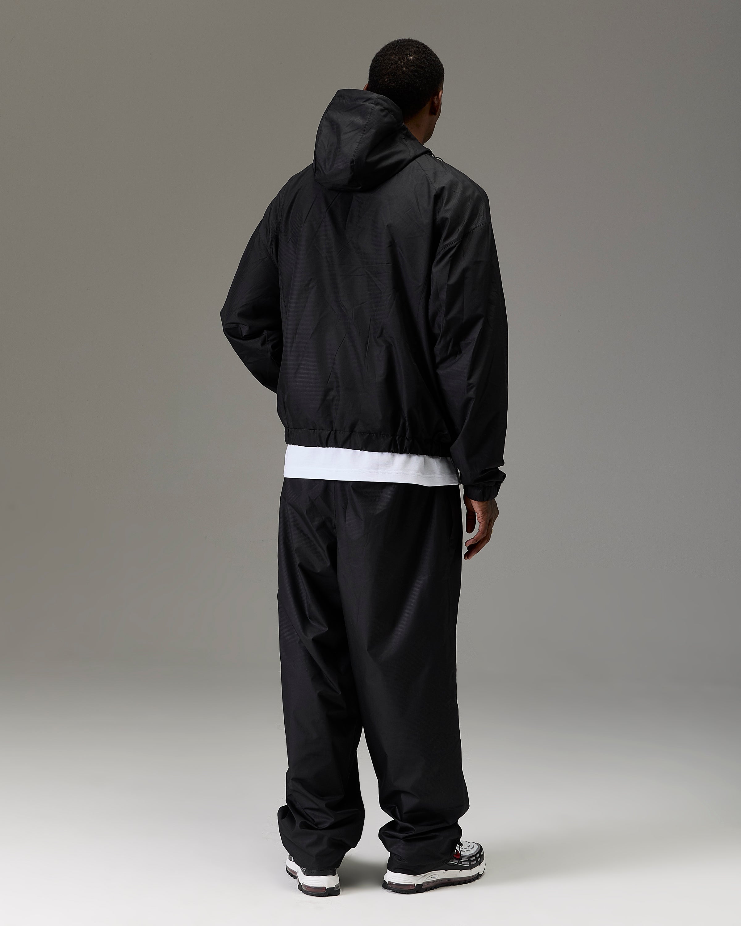 Displays a model wearing the Black 'Hoodrich' branded Men's The Winner's Circle Ripstop Woven Full Tracksuit