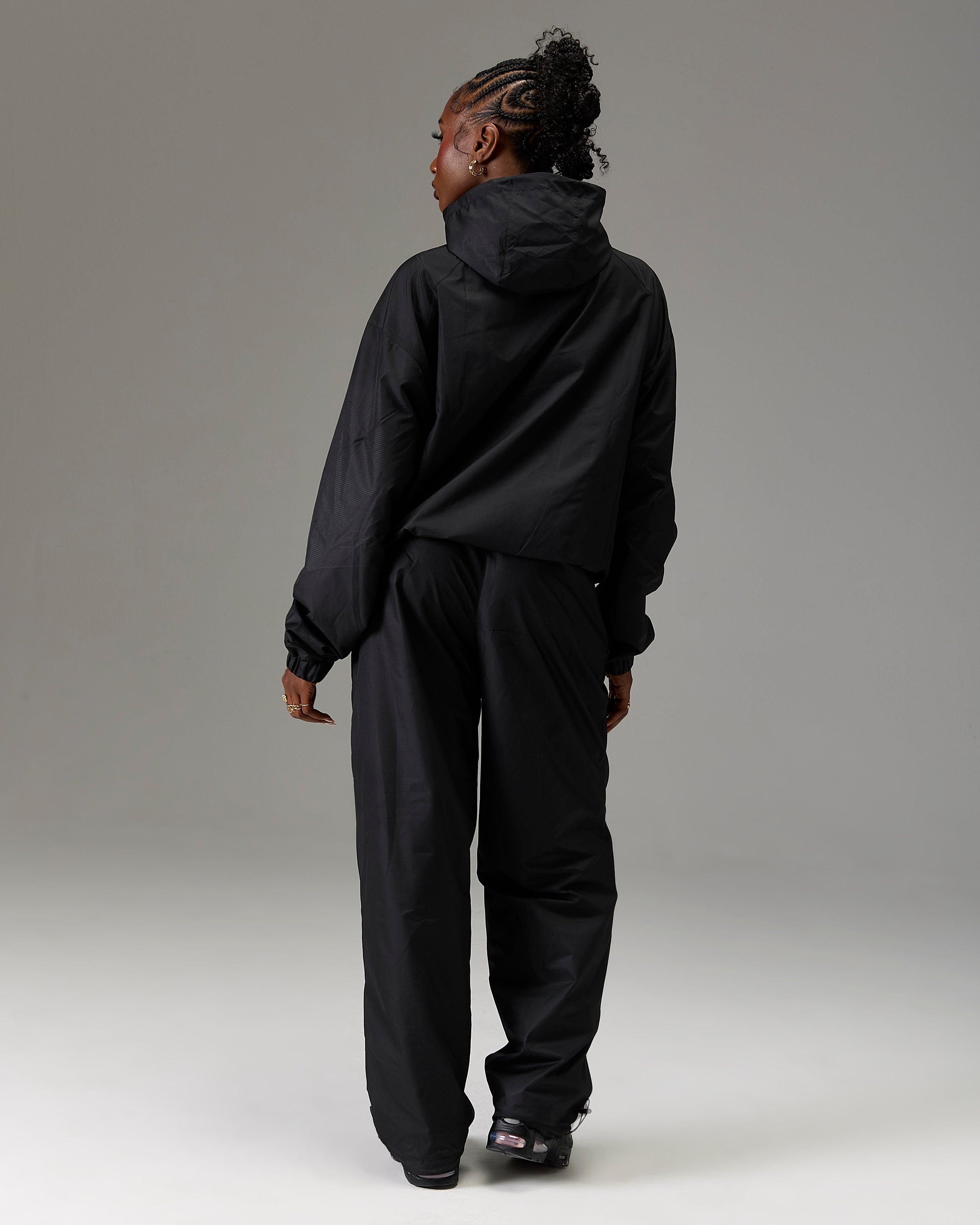 Displays a model wearing the Black 'Hoodrich' branded women's The Winner's Circle Ripstop Woven Full Tracksuit