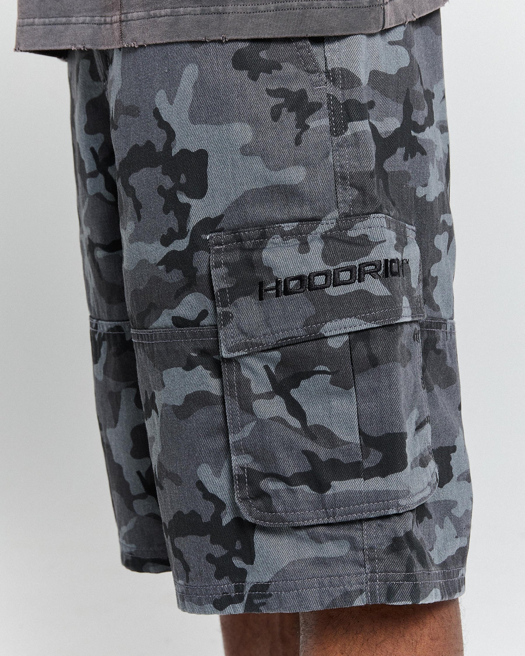 Camouflage shorts with a 'HOODRICH' logo on a white background